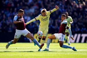 Arsenal's Martin Odegaard (centre) is tackled by Aston Villa's Jacob Ramsey (right) and John McGinn (left)