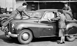 March 1956, the caption reads: 'Donnington W.R.A.C. drivers service a staff car.' They actually seem to be cleaning it. 