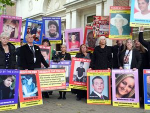Family members of those lost after receiving treatment for mental health concerns hold up pictures during a protest at the Lampard Inquiry
