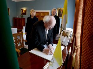 President Michael D Higgins and his wife Sabina, with the Papal Nuncio Archbishop Luis Mariano Montemayor, signing a book of condolences for Pope Francis