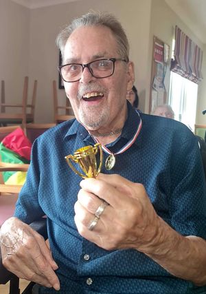 One of the winning residents with his medal presented by Mickey Bushell MBE