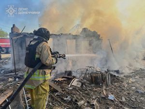 A Ukrainian firefighter puts out a blaze in ruined houses following a Russian air rad in the Donetsk region
