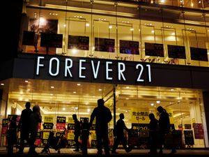 Shoppers walk by a Forever 21 clothing store