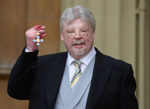 Simon Weston, the Falklands veteran who overcame horrific facial injuries to become a charity campaigner, holds his CBE presented to him by Queen Elizabeth ll during an investiture ceremony at Buckingham Palace, London in 2016