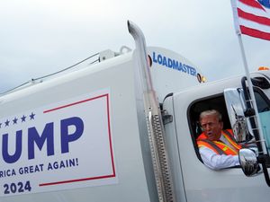 Republican presidential nominee former President Donald Trump talks to reporters as he sits in a garbage truck