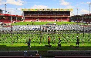 The stage is put together by workmen on the stadium pitch