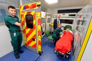 Student paramedics Will Matthews and Olivia Mann with the vice-chancellor and a mock ambulance