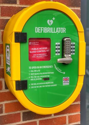 A defibrillator cabinet containing both an automated external defibrillator and a bleed control kit.