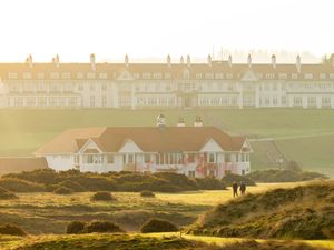 View from a distance of a golf course clubhouse with red spray paint on it