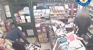 As one man smashes up the till, the other strikes a terrified shop worker with a hammer