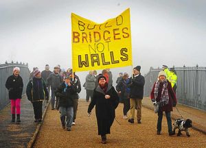 Protesters hold a banner saying 'Build Bridges Not Walls', at Ironbridge as Donald Trump was being inaugurated