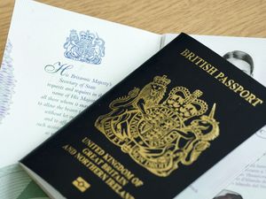 General view of a closed British passport on top of an open passport.