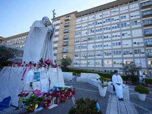 A man prays for Pope Francis in front of the Agostino Gemelli Polyclinic in Rome