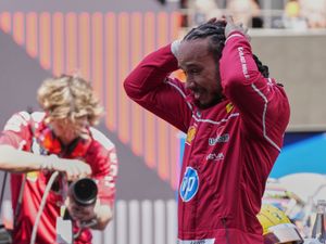 Lewis Hamilton puts both hands on his head in disbelief