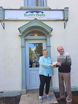 Clive presenting a cheque to Cathy Warlow, Manager of Builth Community Support, outside their Builth Wells offices