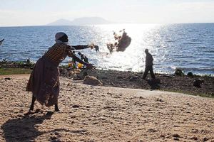 A woman waits for the return of the fishing boats