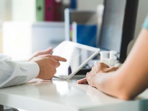 A doctor with a tablet and patient