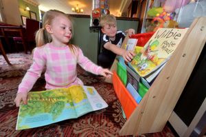 Jessie Williams, 4, and Harry Williams. 8, explore the children's book collection