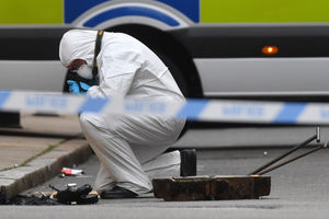 A forensics specialist searches a drain in Birmingham