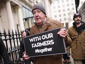 Jeremy Clarkson holding a sign showing his support for fellow farmers