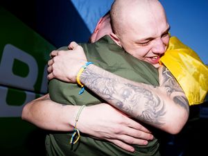 A soldier hugging a returned POW in Ukraine