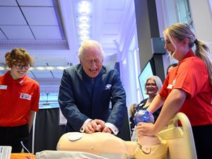 The King performs CPR on a dummy patient during a visit to the Royal College of Nursing in central London