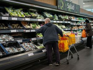 People looking at veg in a supermarket