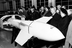 This picture was taken at Cosford Aerospace Museum at RAF Cosford, later called the RAF Museum, Cosford, on or about January 15, 1977. The caption was: 'Civic heads from Shropshire and the West Midlands were guests of RAF Cosford for a day when they were given a conducted tour of the station's aerospace museum. They saw the museum's collection of Second World War German rockets and more conventional aircraft... Squadron Leader Peter Coombes is seen showing the party around the rocket section.'