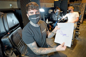 Lee Blackhurst with a stencil of the tattoo at his studio