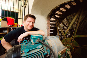 Josh Crouch with the waterwheel and generator which feeds electricity into the National Grid