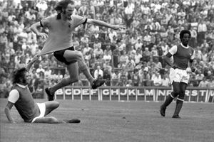 Arsenal's Peter Simpson pulls on the shirt of Derek Dougan of Wolves (PA)