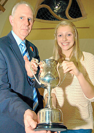 Graham Merrington, secretary of the Shropshire Athletic Association, presents the President's Cup trophy to 15-year-old Emily Ball, from Oswestry