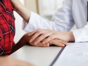 Close up view of female doctor touching patient's hand