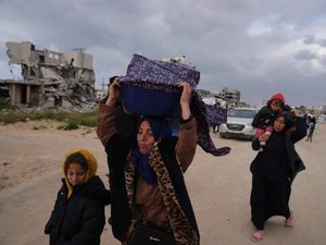 Displaced Palestinians, carrying their belongings, move away from the areas where the Israeli army is operating