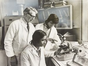 A group of students from Smethwick Hall Boys High School took part in a work experience programme at Hallam Hospital, West Bromwich, to bridge the gap between school and work. The photograph shows Buja Singh and Hitesh Patel examining a microscope, overseen by Mr J. S. Taylor, in February 1975.