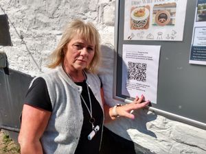 Penny Phillips pins a poster promoting a petition to protect the Monmouthshire and Brecon Canal to a notice board outside her Penelope\'s Cafe at Goytre Wharf. Picture: LDRS