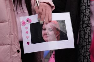 A person holding a photo of Rhiannon Whyte  outside Coventry Crown Court,