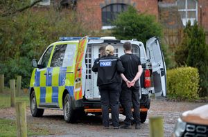 A suspect is led away after being arrested