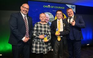 Representatives  of  the NIS Group present the joint Child of Courage Award to: Ellie Taylor and Finley Stevens.