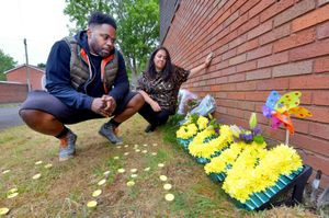 Keelan Wilson's parents, Gary Wilson and Kelly Ellitts with floral tributes left at the scene on the first anniversary of his death