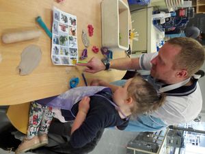 Father and daughter look a some of the sample designs for painting a plate