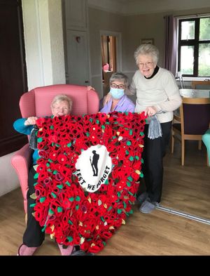 Resident Jean Hancock with activities coordinator Teresa Mason and resident Ann Lawrence with the Remembrance flag knitted at Arden Grange Nursing Home
