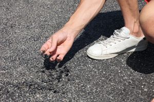 Mark Edwards holding piece of tar that has melted in heatwave on Gorsemoor Road in Cannock. Gorsemoor Road in Cannoc in Staffordshire is melting down in the heatwave. The highways authority has temporarily closed the road, and has been out on Saturday to treat it .