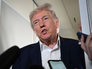 President Donald Trump talks to reporters on board Air Force One