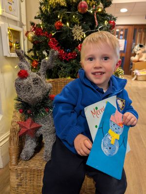 2-year-old Dexter with some of the nursery's Library Christmas card creations.