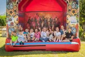 Headteacher Suzanne Shackleton with pupils on the traditional bouncy castle
