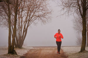 A lone runner rushes through the fog, which obscured the lake.