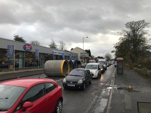 The concrete cylinders in the road outside the car dealership