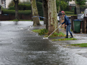 People were trying to push back the flood water from the front of their homes. Picture: Tim Thursfield