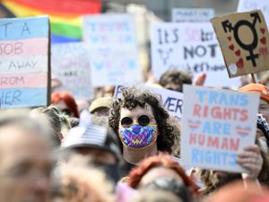 Trans rights protestors holding up placards during a protest